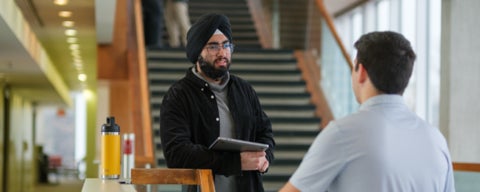 Two students in business casual attire facing each other