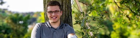 Student sitting with his back against a tree