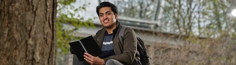 Student reading a book outside