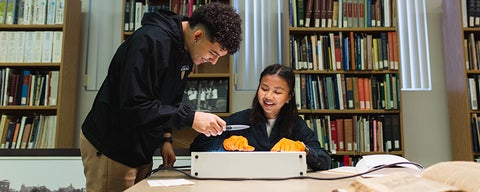 two students in a library working together