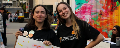 Two students at a Women's Centre event holding a poster
