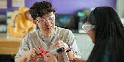 Engineering students working on a robotic arm
