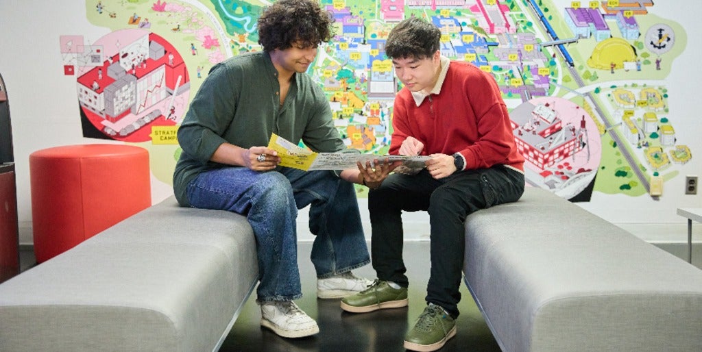 Two students look at a viewbook in the Visitor's Centre