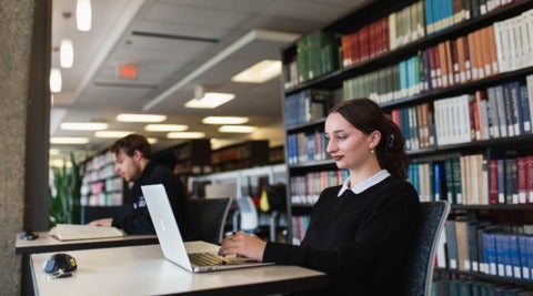 Students use laptops in the library