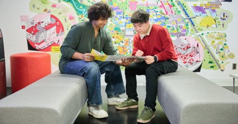 Two students look at a viewbook in the Visitor's Centre