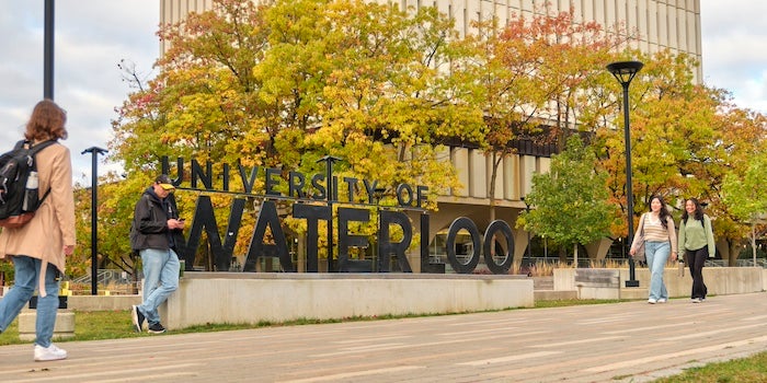 Students walking in front of the Waterloo sign.