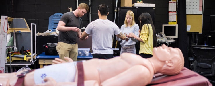 Students in a lab working on a manequin 