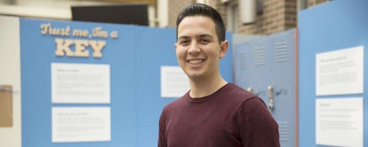 Andrew standing in front of his group's museum exhibit