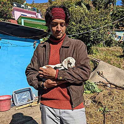 Student holding a small goat