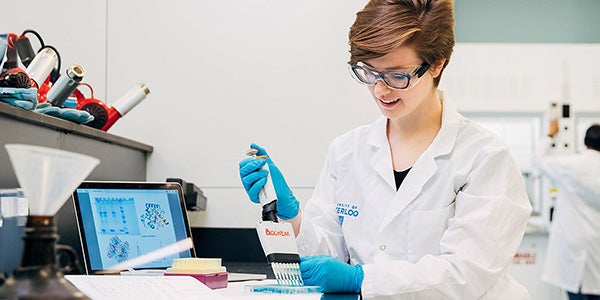 A student in the bachelor of science in biochemistry degree program works in a lab