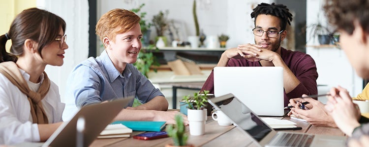 Group of business students sitting around a table chatting