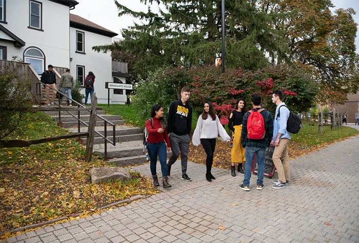 Group of six students standing outside the Grad House, a resturant on Waterloo's main campus