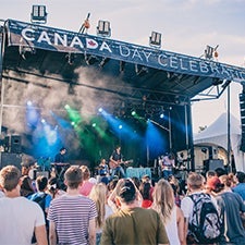 Students watching a band play on a stage at Canada Day