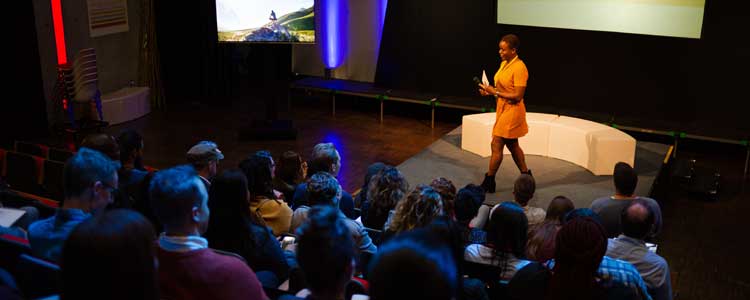 Communications student standing on a stage