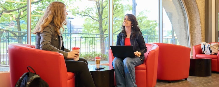 Two people sitting in DP library and talking.