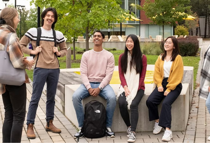 A group of students socializing outdoors on campus.