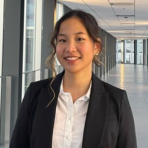 Daisy wears a blouse and blazer and smiles