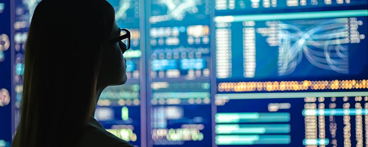 A person looks at a blue screen full of data