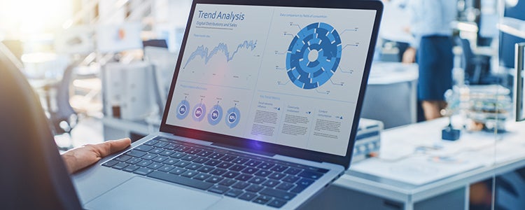 A laptop screen displays charts and graphs