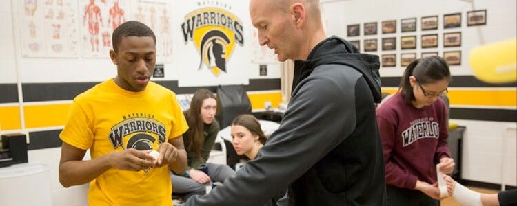 Rob demonstrates proper taping technique to Kinesiology student, Devon.