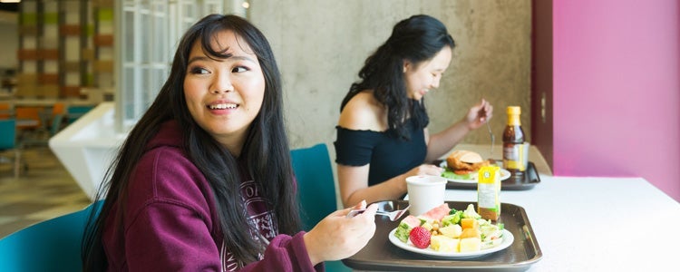 Two students eating healthy food.