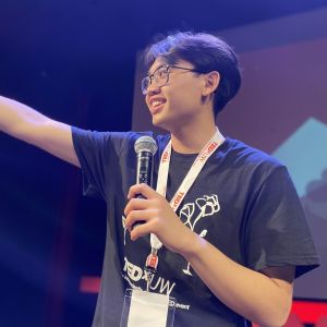 Franklin smiles and holds a microphone as he presents at TEDxUW