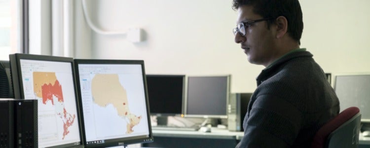 Aujas analyzes a map of Ontario in a Faculty of Environment computer lab