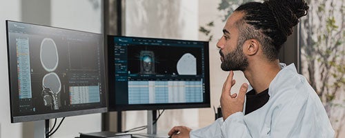 Health student looking at scan of skull on a computer screen