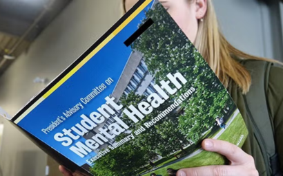 Student reading Student Mental Health brochure