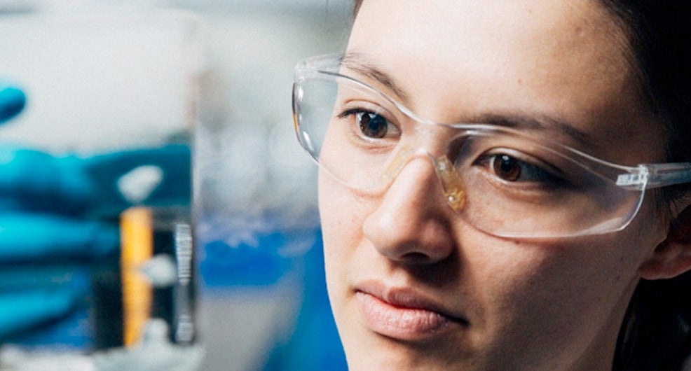 close up of student holding a beaker