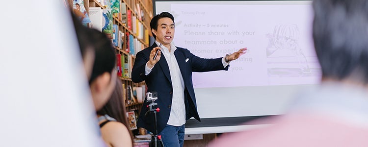  A teacher standing at the front of a classroom giving a lecture.