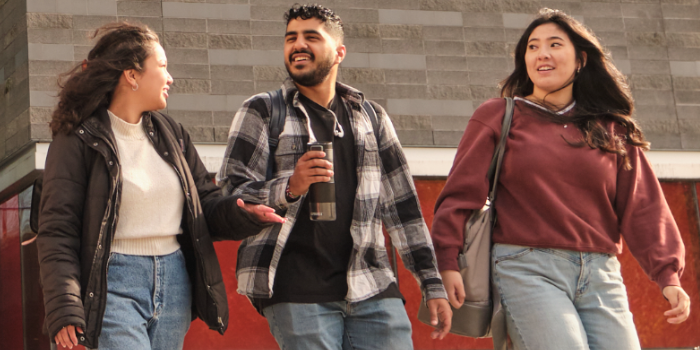 Three students walking on campus