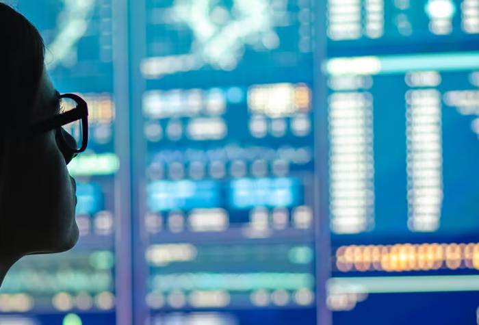 A person looks at an out-of-focus blue-lit screen