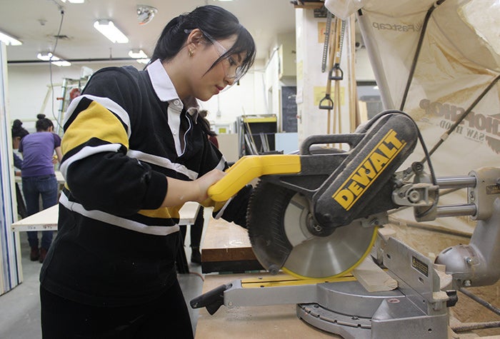 student working with a saw