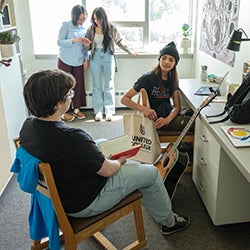 Students sitting in a brightly lit residence room