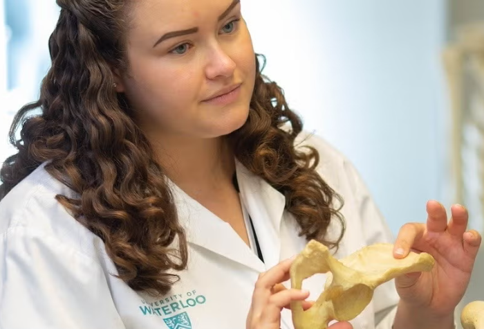 Kinesiology student holding a bone model