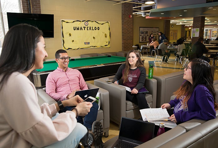 four students talking in a residence common area