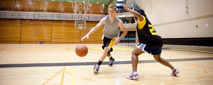 Two students playing basketball