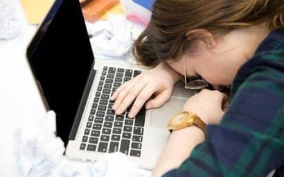 Student resting her head on a desk.