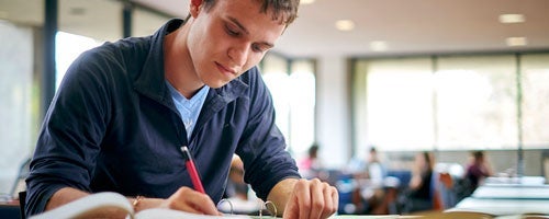 Math student writing in notebook