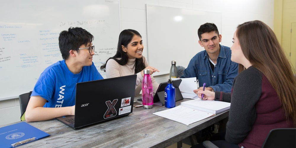 four students talking around a table