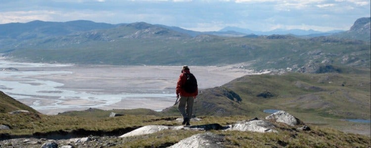 Researcher on top of a mountain in the Arctic.