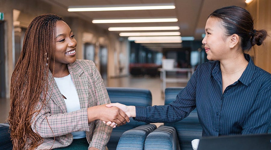 Two woman shake hands