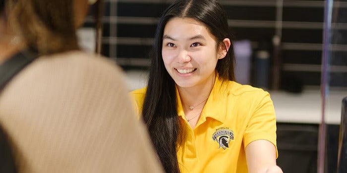 student working at front desk at pac