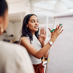 A woman presents in front of a whiteboard