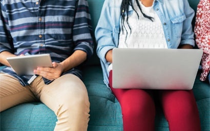 students sitting next to each other on their devices