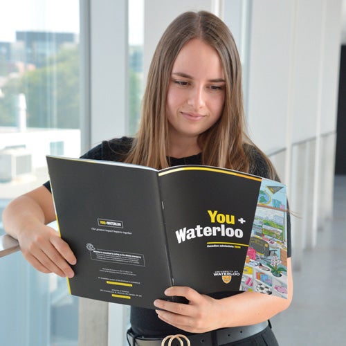 A student reads the University of Waterloo's viewbook