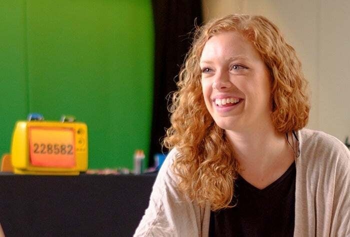 Rachael smiles in front of a green background