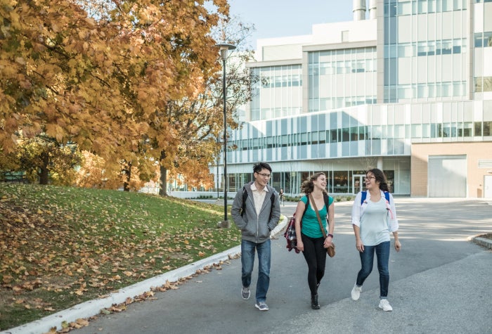 three students walking through campus