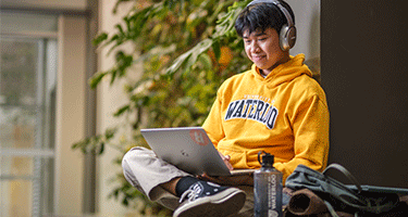 Current Environment student working on their laptop in the Environment 3 building.